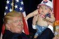 The final stretch: Donald Trump on stage with six-month-old Catalina Larkin in Florida.