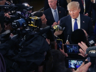 Donald Trump surrounded by reporters.