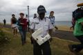 National Police Brigadier Gisele Cadar carries the plastic beach debris away from St Denis beach, Reunion Island on Tuesday.