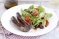 Spicy sausages with roasted tomato salad