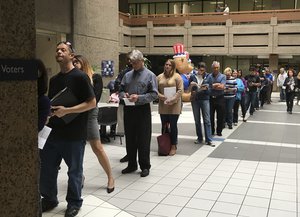 The line of voters waiting to cast an early ballot at the Santa Clara County Registrar of Voters' office winds into the building's atrium Monday, Nov. 7, 2016, in San Jose, Calif.