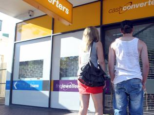 Young couple standing in front of closed Cash Converters store on Gouger Street, Adelaide.