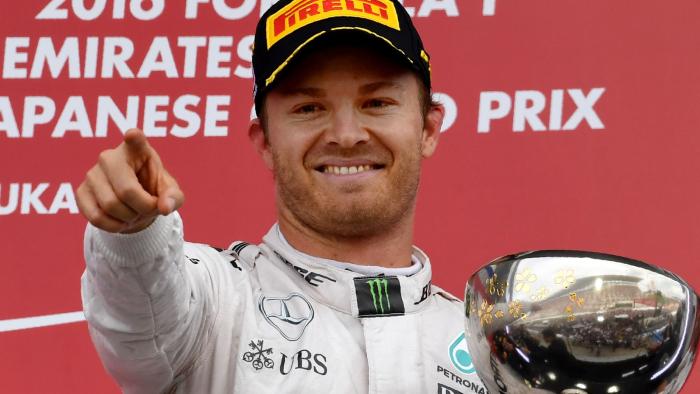 Mercedes AMG Petronas F1 Team's German driver Nico Rosberg holds the cup as he celebrates winning first place on the podium after the Formula One Japanese Grand Prix race in Suzuka on October 7, 2016. / AFP PHOTO / TOSHIFUMI KITAMURA