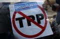 A supporter of Senator Bernie Sanders, an independent from Vermont, holds a sign against the Trans-Pacific Partnership ...