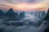 A view of the many karst mountains peaking through a river of fog. Taken on spring morning in Guangxi, China.