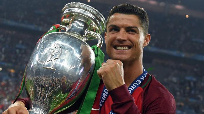 TOPSHOT - Portugal's forward Cristiano Ronaldo smiles while posing with the trophy after Portugal won the Euro 2016 final football match between Portugal and France at the Stade de France in Saint-Denis, north of Paris, on July 10, 2016. / AFP PHOTO / FRANCISCO LEONG