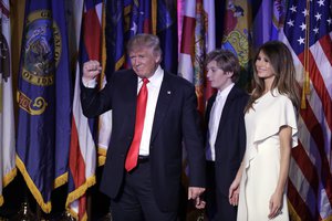 President-elect Donald Trump pumps his fist after giving his acceptance speech as his wife Melania Trump, right, and their son Barron Trump follow him during his election night rally, Wednesday, Nov. 9, 2016, in New York.