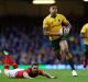 At full flight: Israel Folau leaves the Welsh defence in his wake on Saturday.