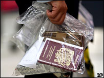 A passenger at Manchester airport in the UK with a plastic bag containing travel documents, 10 August 2006