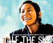 Smiling woman's face against a mottled blue sky. Text reads: International Women's Day Development Agency Presents: Half the Sky