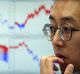 A currency trader watches monitors at the foreign exchange dealing room of the KEB Hana Bank headquarters in Seoul, ...