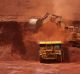 An excavator loads ore into an autonomous dump truck at Fortescue Metals Group Ltd.'s Solomon Hub mining operations in ...