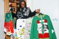 Whoopi Goldberg with the collection of 'ugly Christmas sweaters' she designed.