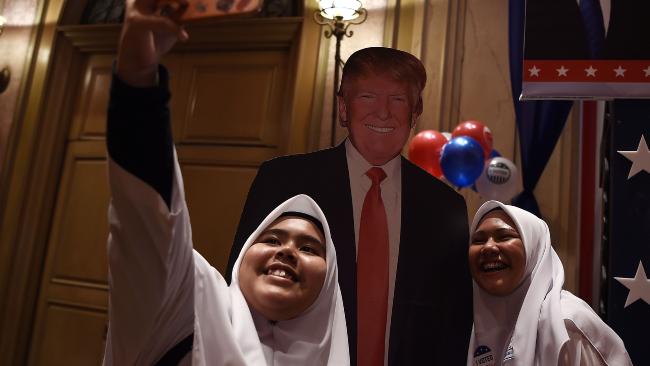 Malaysian Muslim school girls pose for a selfie with a cut-out of the US presidential candidate Donald Trump. Picture: AFP