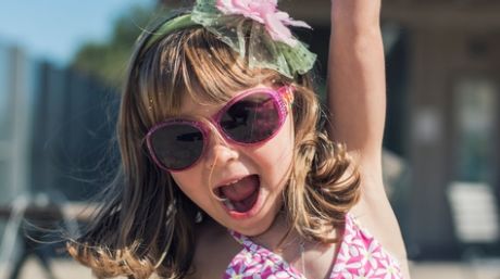 Little girl having fun at the beach in a sunny day Being playful, for Daily Life article?