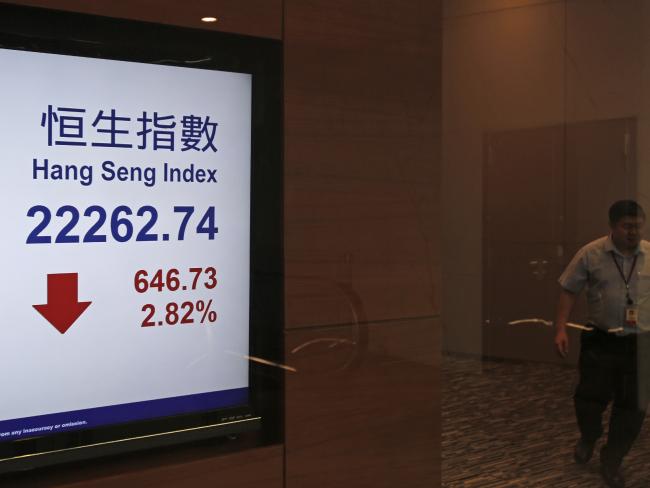 A man walks past a display of the Hang Seng index at Hong Kong Stock Exchange. Picture: AP