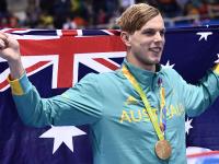 Australia's Kyle Chalmers waves his national flag
