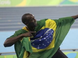 Jamaica's Usain Bolt holds the flag of Brazil after winning the gold medal in the men's 4x100-meter relay final during the athletics competitions of the 2016 Summer Olympics at the Olympic stadium in Rio de Janeiro, Brazil, Friday, Aug. 19, 2016. (AP Photo/David Goldman)