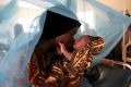 Mariam Kasim, a refugee from the Democratic Republic of Congo carries her one day old baby Sarah Bonamaxi at the ...