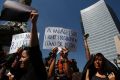 A protester holds a sign that reads in Spanish: "They didn't ask my aggressor how he was dressed," during a ...