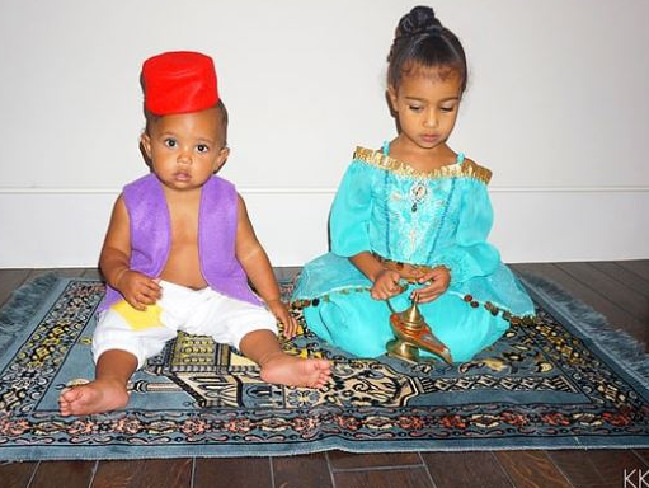 Saint and North West pose in Aladdin-inspired costumes while sitting on their own magic carpet taken from 
<a href="https://www.kimkardashianwest.com/">kimkardashianwest.com.</a>