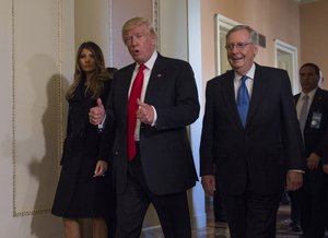 President-elect Donald Trump, flanked by his wife Melania and Senate Majority Leader Mitch McConnell of Ky., gives a thumbs-up while walking on Capitol Hill in Washington, Thursday, Nov. 10, 2016, after their meeting.