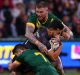 PERTH, AUSTRALIA - OCTOBER 15: Jordan Kahu of New Zealand gets tackled by Cooper Cronk and Josh Dugan of Australia ...