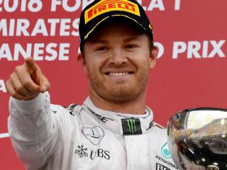 Mercedes AMG Petronas F1 Team's German driver Nico Rosberg holds the cup as he celebrates winning first place on the podium after the Formula One Japanese Grand Prix race in Suzuka on October 7, 2016. / AFP PHOTO / TOSHIFUMI KITAMURA