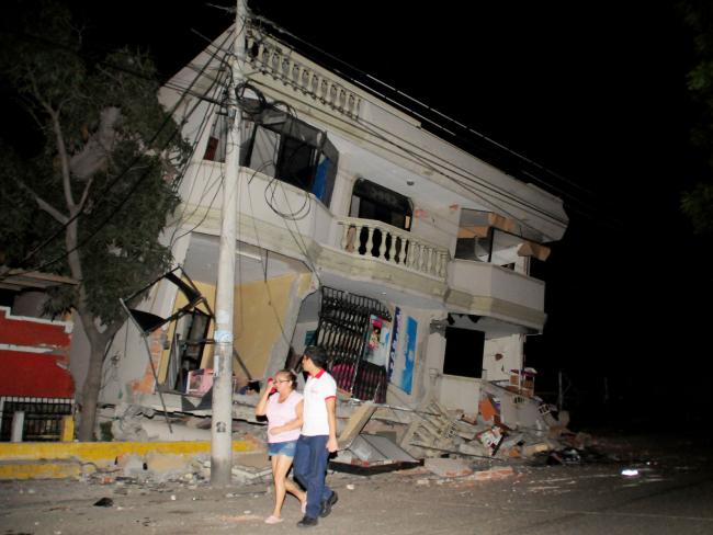 Residents walk on a street amid destroyed buildings following the 7.8-magnitude earthquake that struck northwestern Ecuador. Picture: AFP