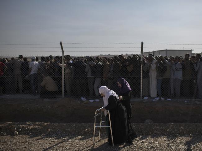 An elderly displaced woman is helped as she arrives to the Hassan Sham camp, east of Mosul. Iraqi forces are fighting to gain control of the area from the Islamic State. Picture: AP Photo/Felipe Dana