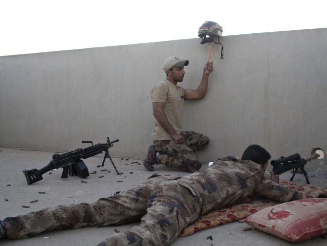 An Iraqi special forces soldier puts up a helmet as a decoy as a sniper gets ready to fire on Islamic State positions in Gogjali, on the eastern edges of Mosul, Iraq. Picture: AP