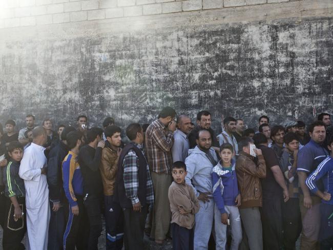 People queue to receive aid packages in Gogjali, on the eastern edge of Mosul, Iraq. Picture: AP