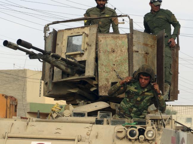 Iraqi Shiite Hezbollah Brigade militiamen prepare their armoured vehicles for fighting against the Islamic State group in Iraq. picture: AFP