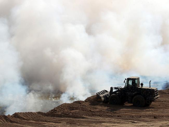 Iraqi forces attempting to extinguish the flames after Islamic State (IS) group jihadists torched Mishraq sulphur factory, near the Qayyarah base, about 30 kilometres south of Mosul. Picture: AFP