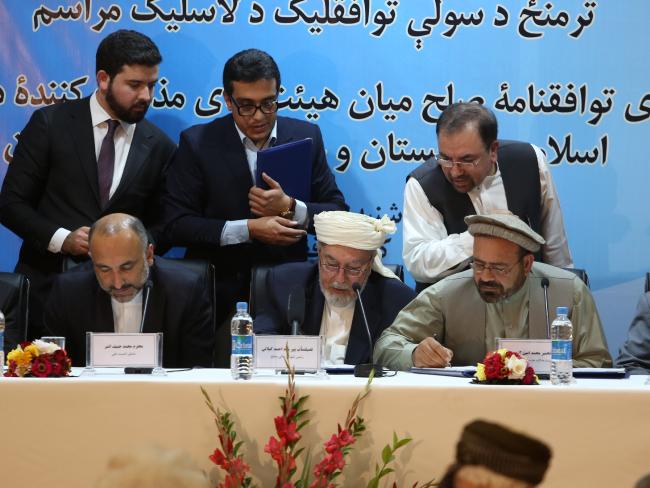 Amin Karim, representative of Gulbuddin Hekmatyar, second right, Ahmad Gilani head of Afghanistan's High Peace Council, centre, and Afghanistan national security adviser Mohammad Hanif Atmar, left, sign a peace agreement in Kabul last month. Picture: Rahmat Gul