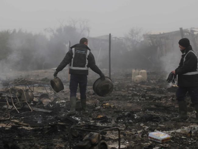 A worker clears up the remains after tents were burnt in the makeshift migrant camp known as &quot;the jungle&quot; near Calais, northern France. Picture: AP