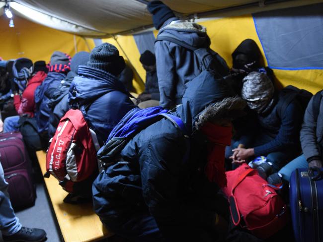 The clearing is expected to take three days. Pictured, migrants wait before boarding buses bound for asylum centres across the country. Picture: AFP PHOTO / DENIS CHARLET