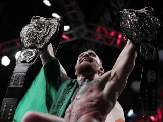 Conor McGregor holds up his title belts after he defeated Eddie Alvarez during a lightweight title mixed martial arts bout at UFC 205, early Sunday, Nov. 13, 2016, at Madison Square Garden in New York. (AP Photo/Julio Cortez)