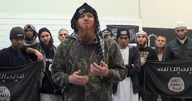 Smith (centre), Thorne (fourth from right) are pictured with others in front of ISIS flags