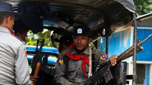 In this Thursday, Oct. 13, 2016 photo, Myanmar police officers sit in a truck as they provide security in Maungdaw, ...