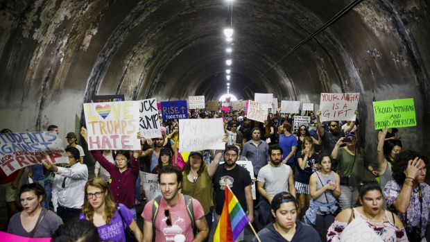 Demonstrators hold signs while marching through the Third Street tunnel during a protest in Los Angeles, California, on ...