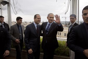 Israeli Prime Minister Benjamin Netanyahu,m center right, waves as he walks with Jerusalem Mayor Nir Barkat, center left, following statements to the press, in Jerusalem, Monday, Feb. 23, 2015.