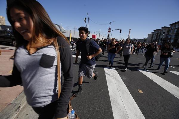 Students run across the intersection at 1st and Alameda streets during an anti-Trump walkout on Monday. (Brian van der Brug / Los Angeles Times)