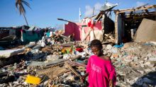 FILE - This is a Wednesday, Oct. 12, 2016. file photo of a girl as she walks through debris where homes once stood after ...