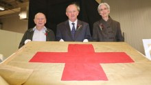 George Roscoe, John Day and WA Historical Society curator Wendy Lugg with the Red Cross flag.