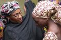 One of the released girls (right) is met by a Nigerian government official in Abuja.