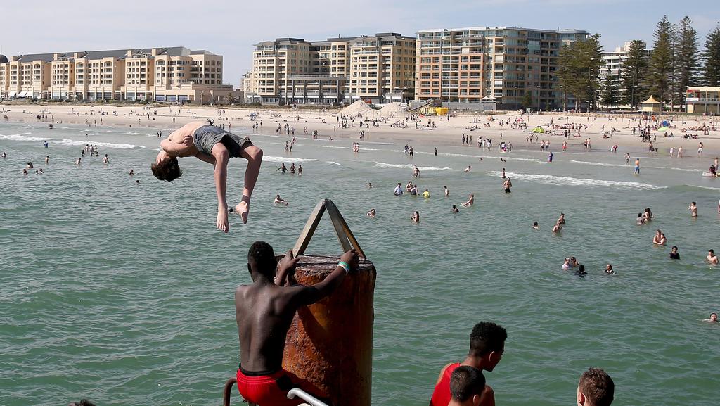 Young men jumping off the Glenelg jetty last summer. Picture: Simon Cross.