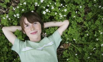 Dreamy boy lying on grass