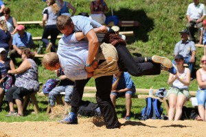 A wrestling high. To win, one wrestler must force his opponent onto the floor, and pin his shoulders to the sawdust.