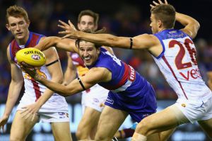 Marcus Bontempelli gets a handball away in traffic against the Lions.